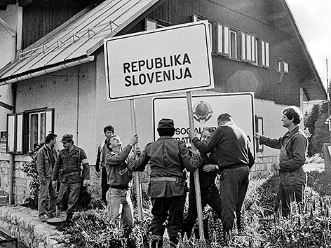 Männer der slowenischen Miliz mit einer Tafel mit der Aufschrift "Republik Slowenien" am 29. Juni 1991.